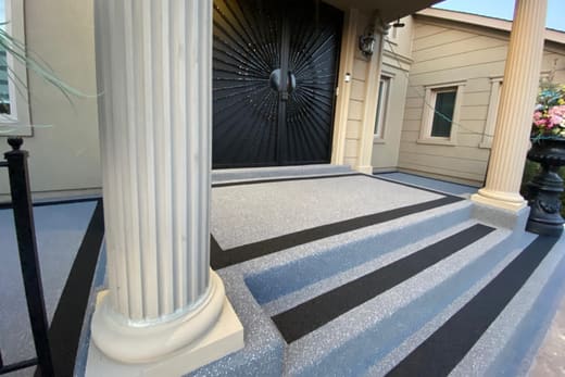 Close view of grey Gator Grip surfacing with black rubber inlay stripes on a set of entry steps